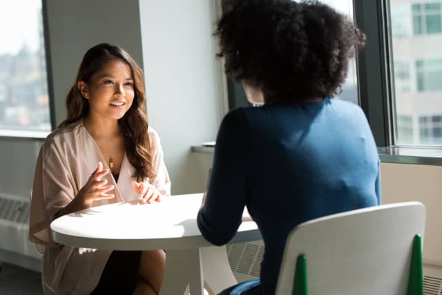 two professional women discussing at table